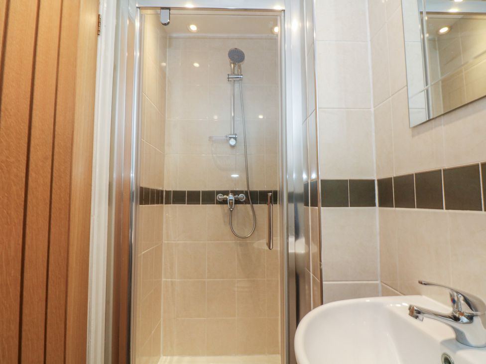 A shower with a sink and mirror at 32B Bank Street Rossendale