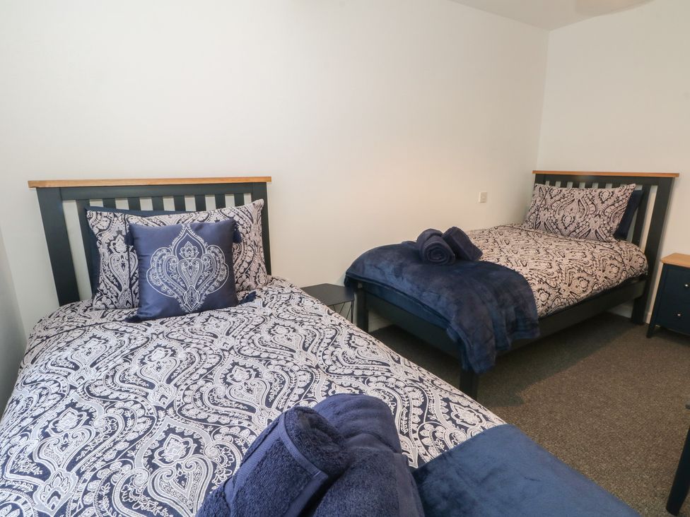 A bedroom with two beds and bedding at 32B Bank Street in Rossendale