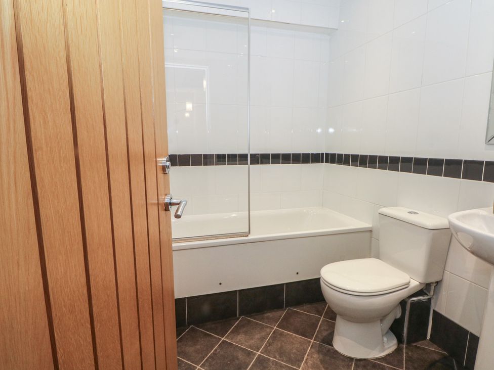A bathroom with a bath tub, toilet, and sink at 32B Bank Street Rossendale