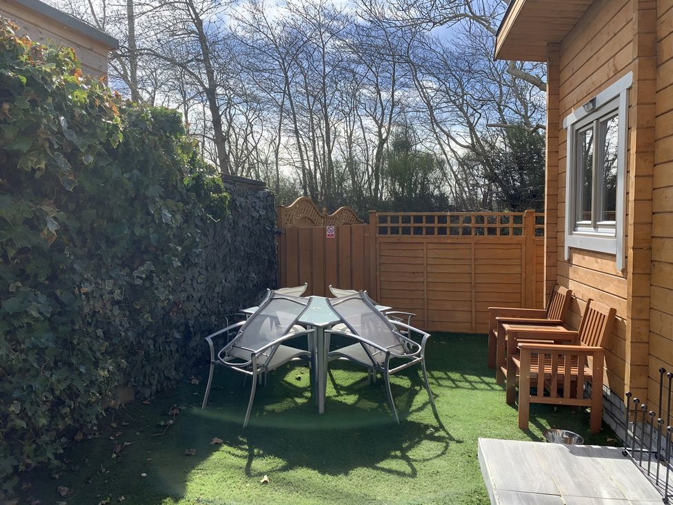 A garden with a table and chairs at Duncairin cabins