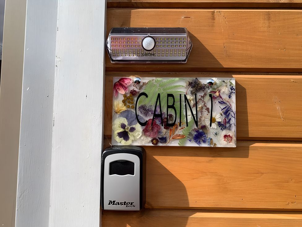 A nameplate with flowers and a light at Duncairin cabins