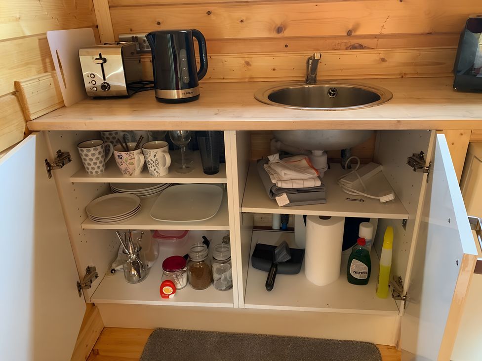 A kitchen with a kettle, toaster, sink, and various kitchen items at Duncairin cabins 