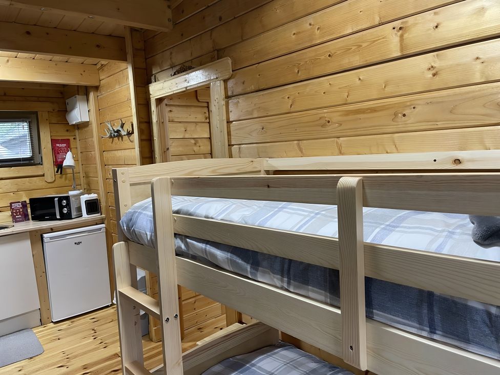A bedroom with a bunk bed and kitchenette at Duncairin cabins