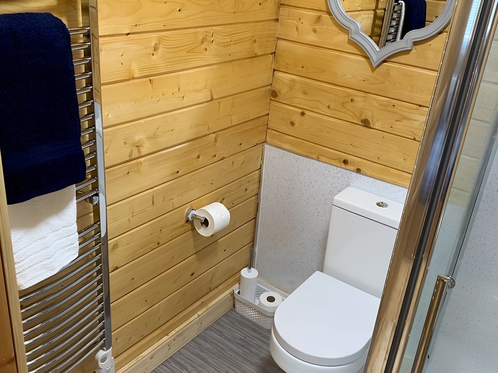 A bathroom with shower, toilet, and towel rack at Duncairin cabins