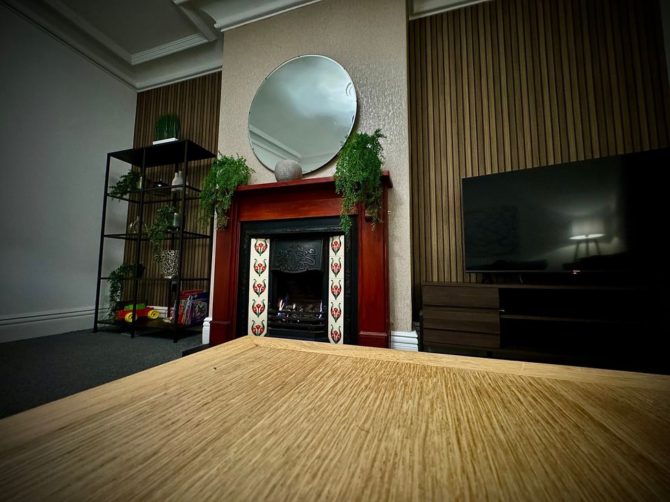 A living room with a fireplace and TV at Horncliffe Hot Tub House