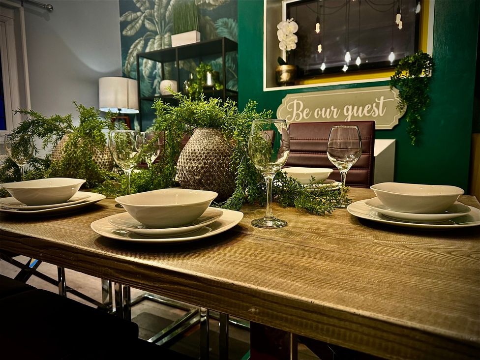 A dining table set with plates and glasses at Horncliffe Hot Tub House