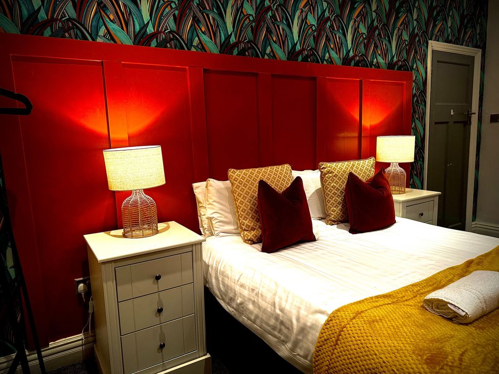 A bedroom with a bed and bedside tables at Horncliffe Hot Tub House