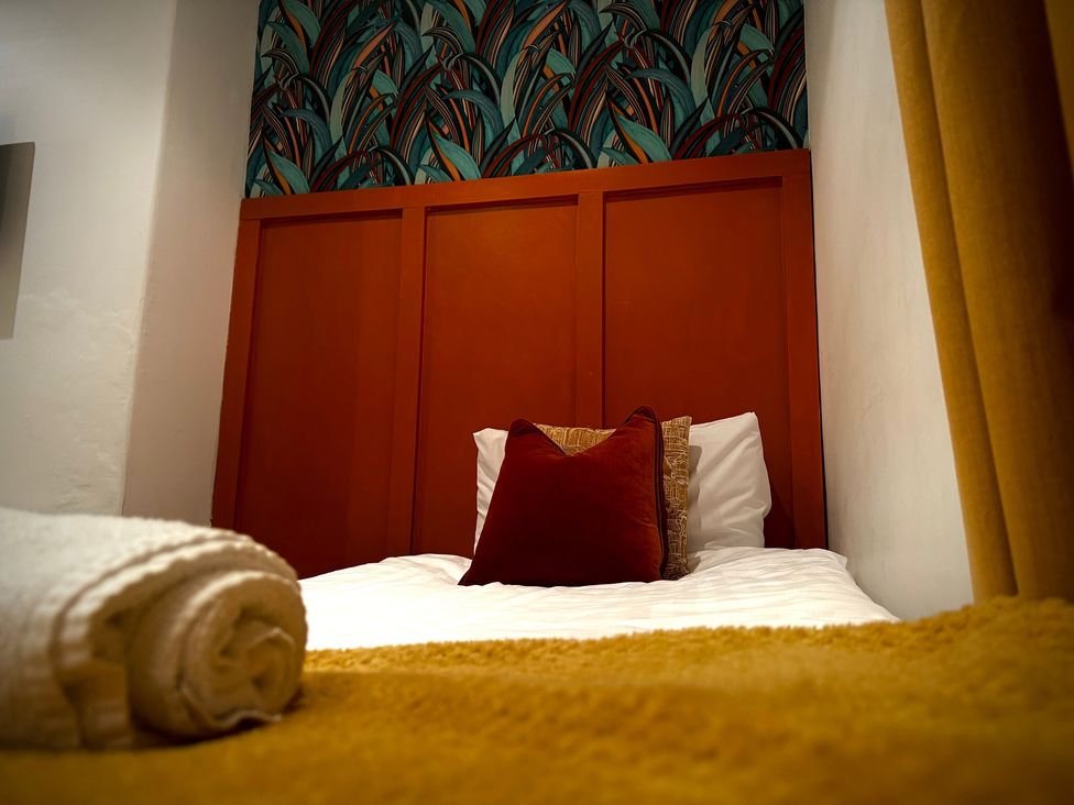 A bedroom with a bed and pillows at Horncliffe Hot Tub House