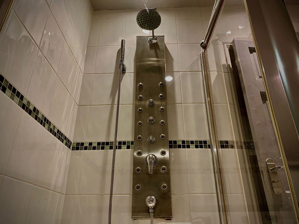 A shower with a stainless steel panel and multiple water controls at Horncliffe Hot Tub House