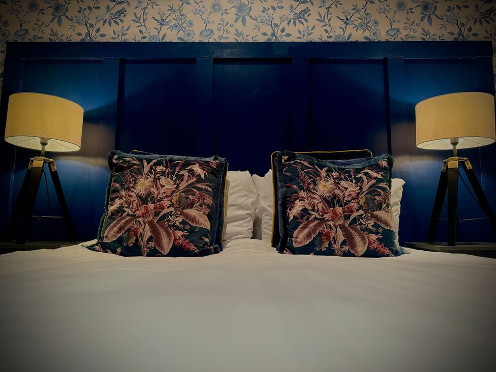 A bedroom with a bed and lamps at Horncliffe Hot Tub House