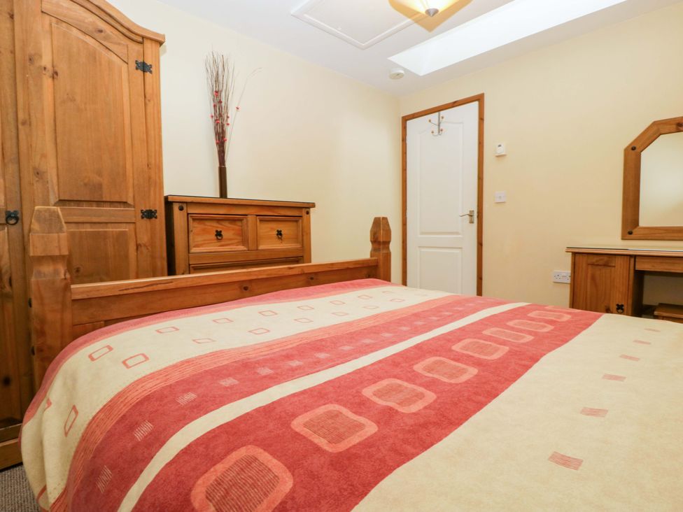 A bedroom with a bed, wardrobe, and chest of drawers at Orchard Cottage in Corse near Gloucester
