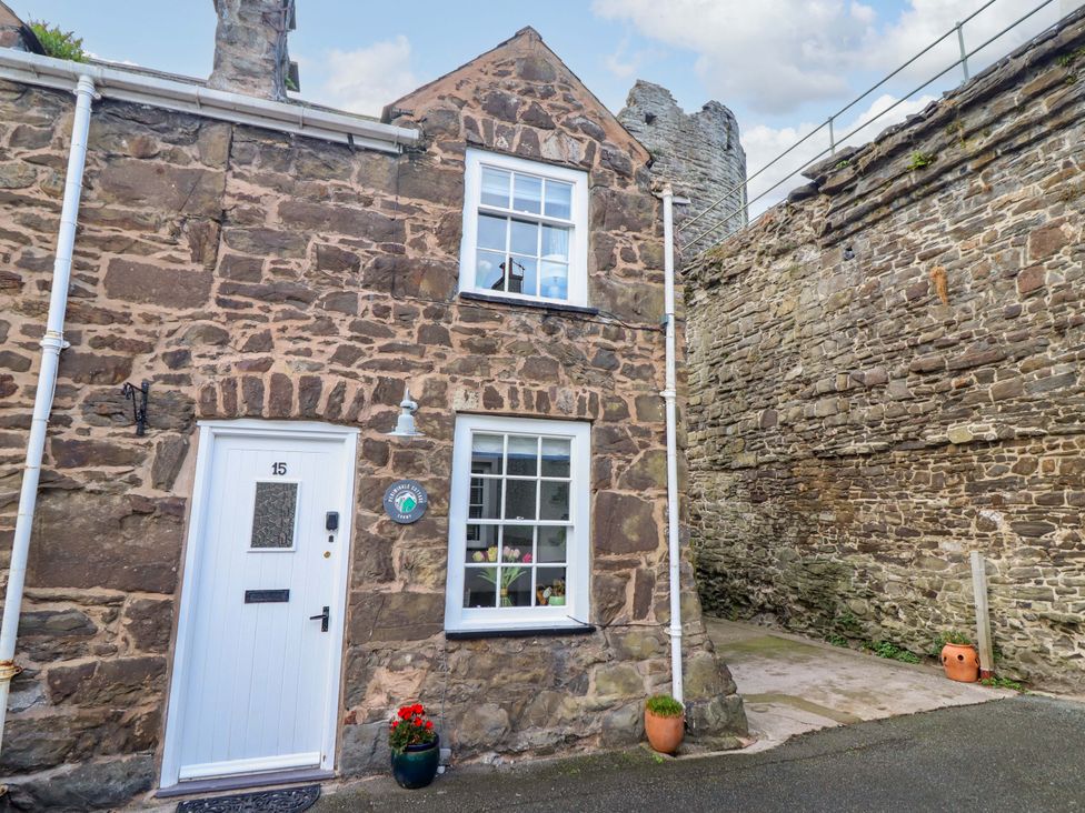 A stone cottage exterior with a front door and window at Periwinkle Cottage in Conwy