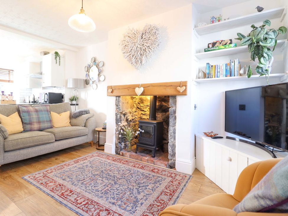 A living room with a fireplace and couch at Periwinkle Cottage in Conwy