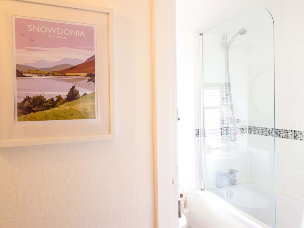 A bathroom featuring a shower and bathtub at Periwinkle Cottage in Conwy