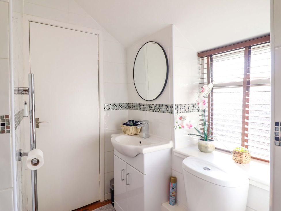 A bathroom with a sink and toilet at Periwinkle Cottage in Conwy