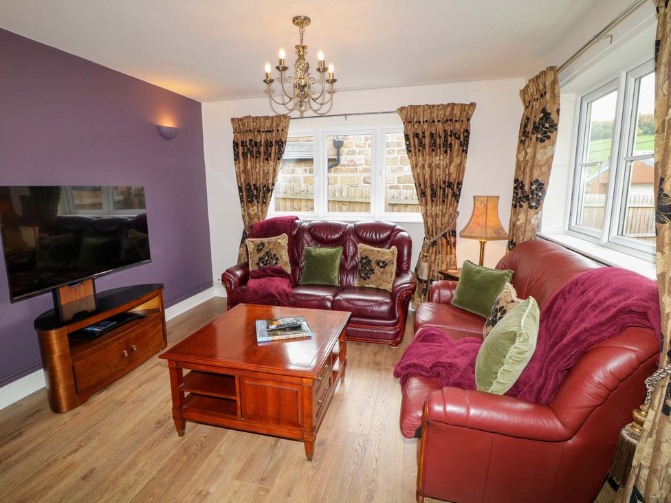 A living room with a sofa, coffee table, and television at The Annex in Belper