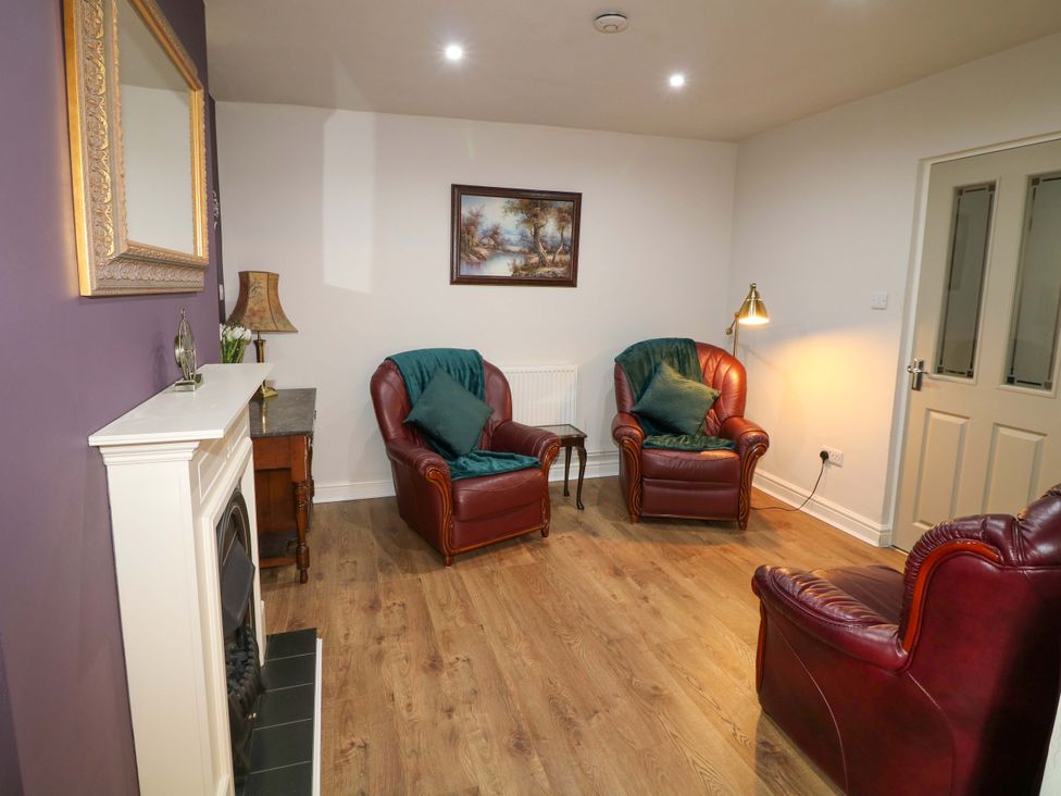 A living room with two armchairs and a fireplace at The Annex in Belper