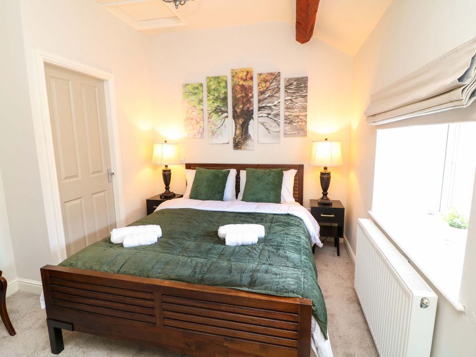 A bedroom with a double bed and wall art at The Annex in Belper