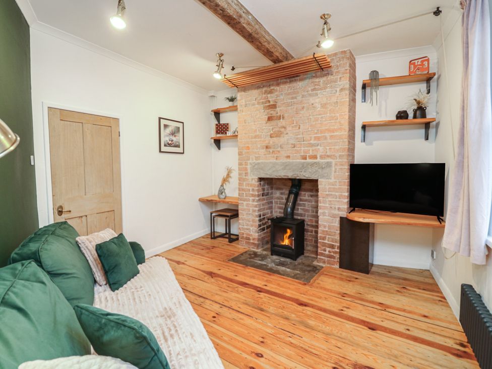 A living room with a fireplace and television at 1 Nottingham Road in Southwell