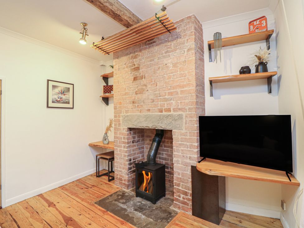 A living room with a fireplace and television at 1 Nottingham Road in Southwell