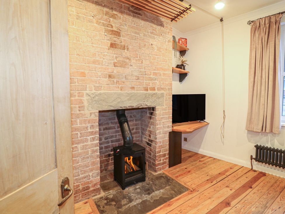 A snug with a fireplace and television at 1 Nottingham Road Southwell