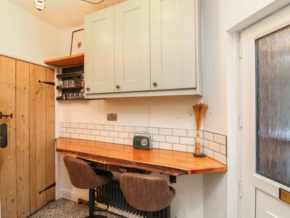 A kitchen area with wall-mounted cabinets and wooden countertop at 1 Nottingham Road Southwell