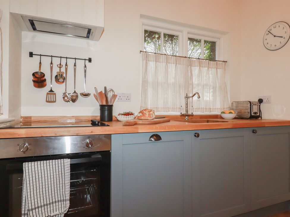 A kitchen with a sink and cooking appliances at Copper Mine Cottage, Bodmin