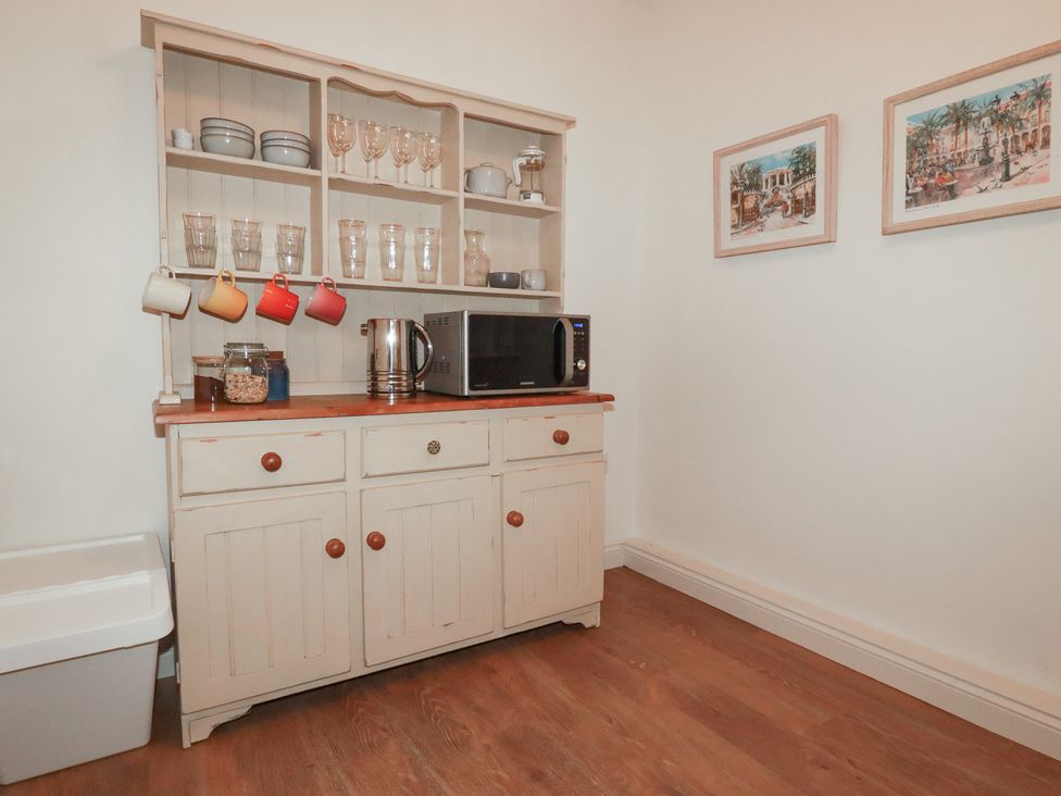 A kitchen with a cupboard and microwave at Copper Mine Cottage in Bodmin