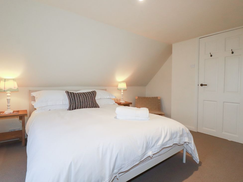 A bedroom with a bed and side tables at Copper Mine Cottage in Bodmin