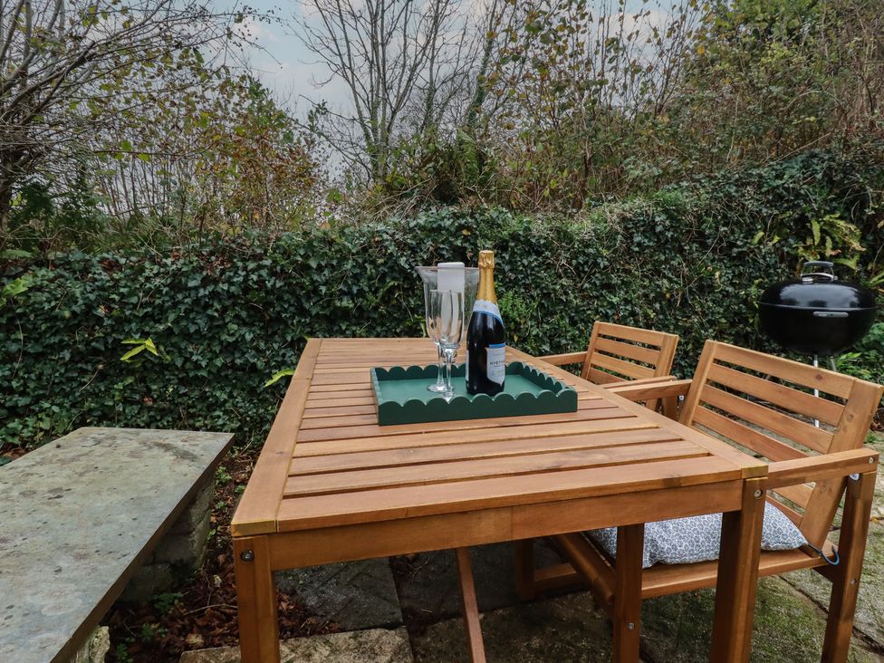A table with champagne and glasses at Copper Mine Cottage in Bodmin