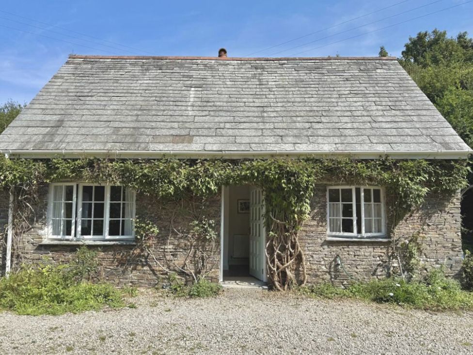 A cottage with a gravel pathway and ivy at Copper Mine Cottage in Trelill near Port Isaac