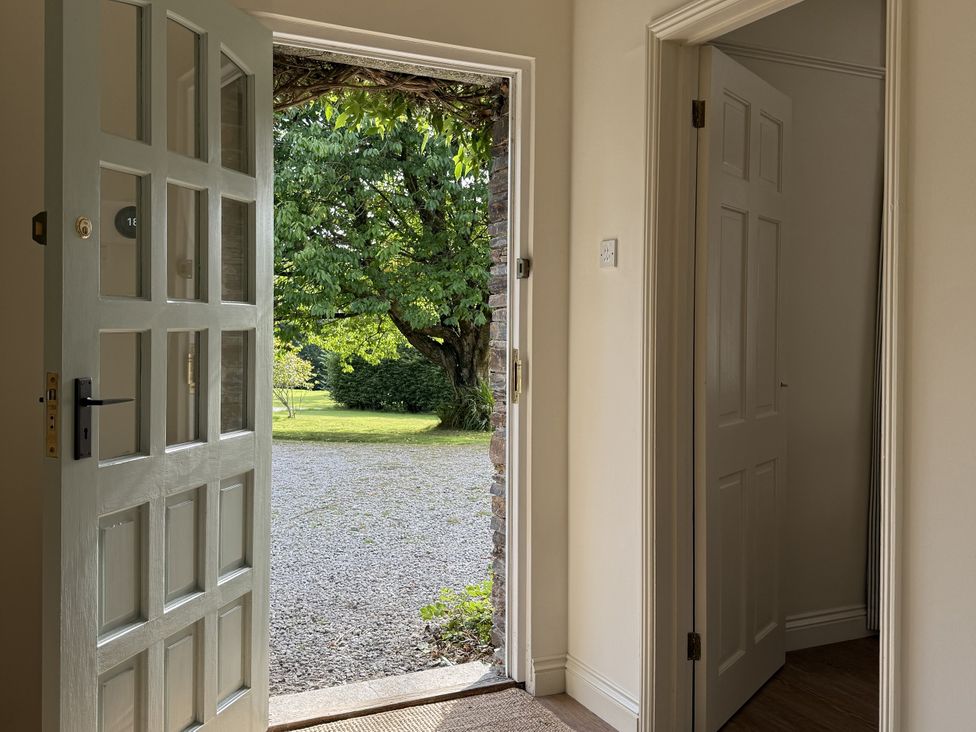 An entryway with an open door leading to a garden at Copper Mine Cottage Trelill near Port Isaac