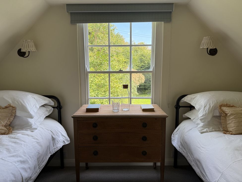 A bedroom with two beds and a chest of drawers at Copper Mine Cottage Trelill near Port Isaac