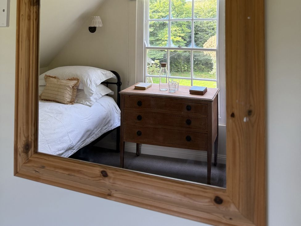 A bedroom with a bed and a chest of drawers at Copper Mine Cottage in Trelill near Port Isaac