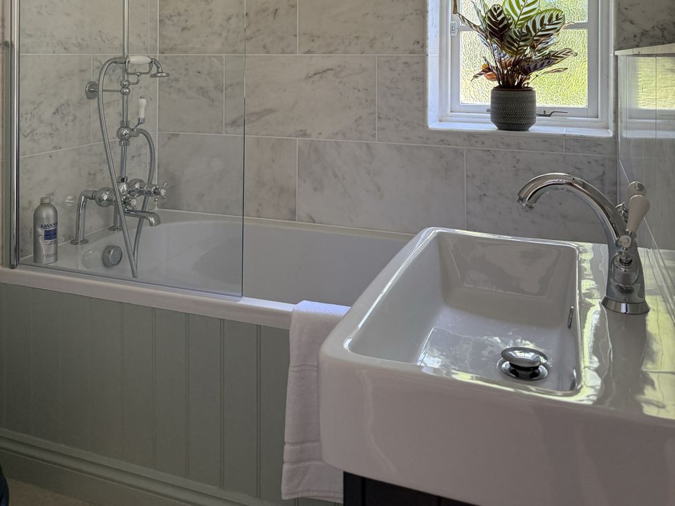 A bathroom with a bathtub and sink at Copper Mine Cottage Trelill near Port Isaac