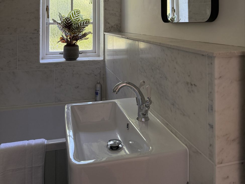 A sink with a faucet and plant at Copper Mine Cottage Trelill near Port Isaac