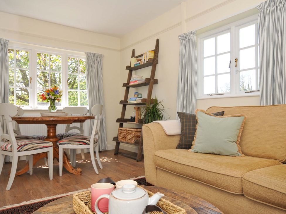 A living room with a dining table and chairs at Copper Mine Cottage Trelill near Port Isaac