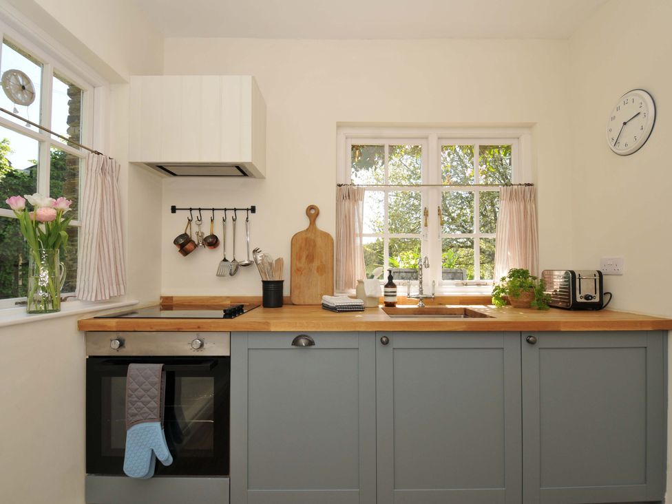 A kitchen with a sink, oven, and various utensils at Copper Mine Cottage, Trelill near Port Isaac