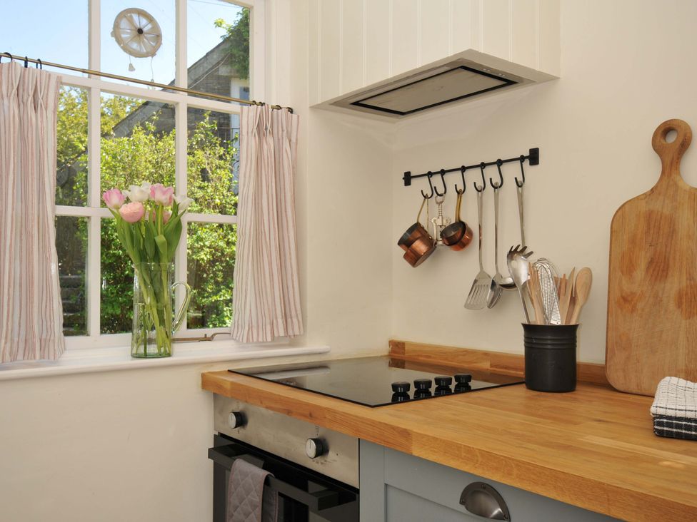 A kitchen with a window and cooking utensils at Copper Mine Cottage Trelill near Port Isaac