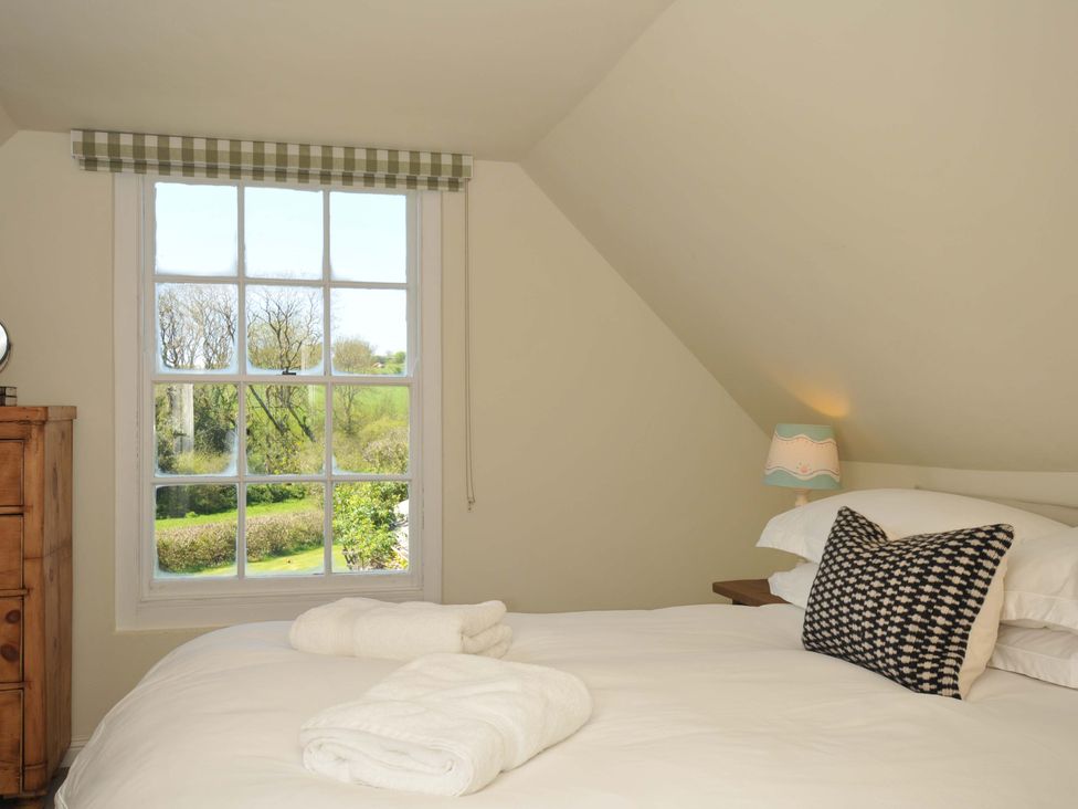 A bedroom with a window and bed at Copper Mine Cottage Trelill near Port Isaac