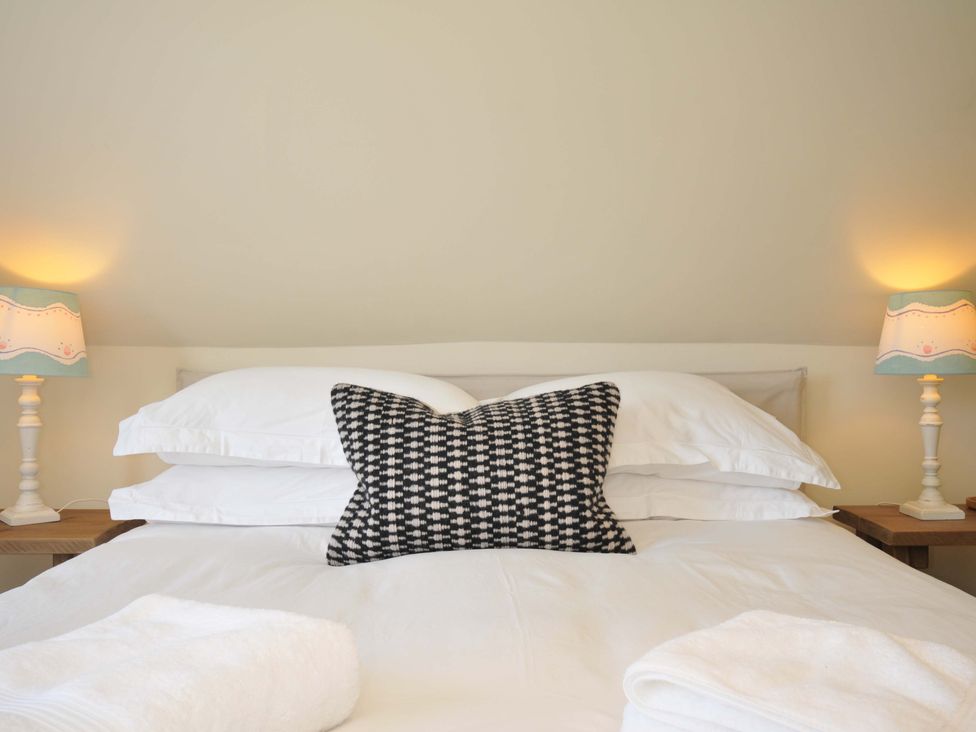 A bedroom with a bed and bedside lamps at Copper Mine Cottage in Trelill near Port Isaac