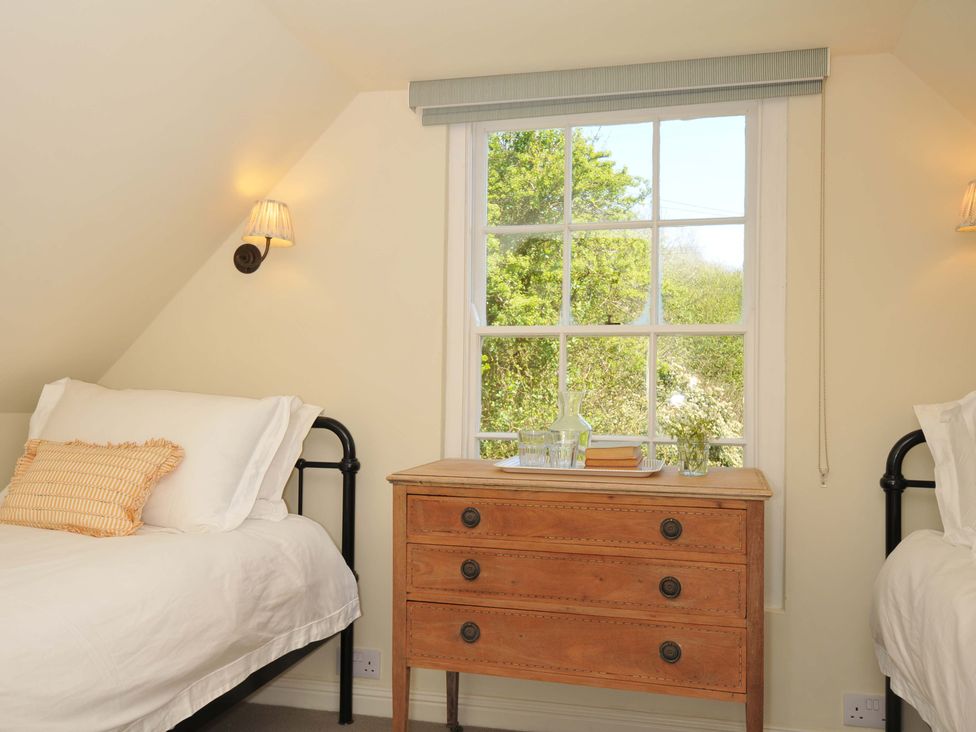 A bedroom with two beds and a chest of drawers at Copper Mine Cottage Trelill near Port Isaac