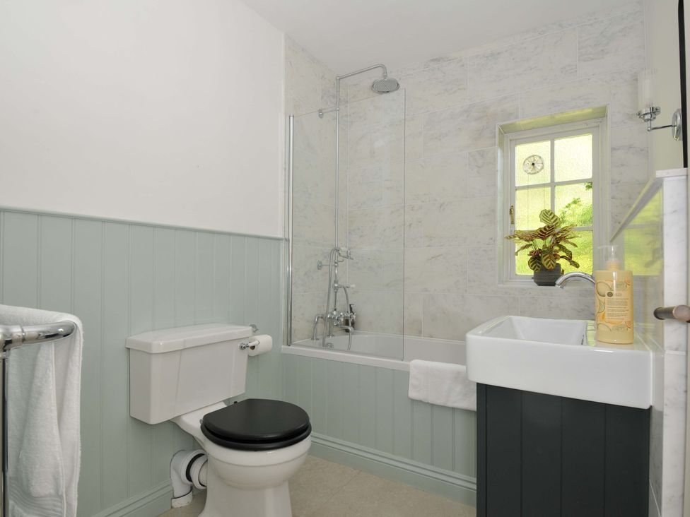 A bathroom with a bathtub and shower at Copper Mine Cottage in Trelill near Port Isaac