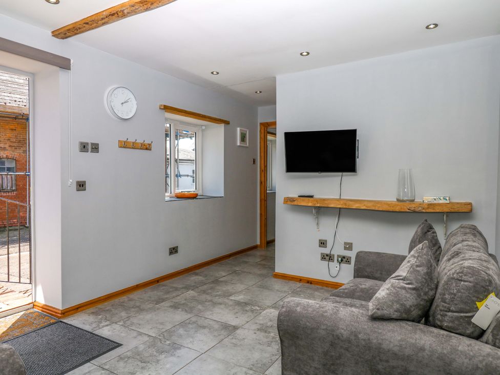 A living room with a sofa and television at The Milk Shed in Plymtree