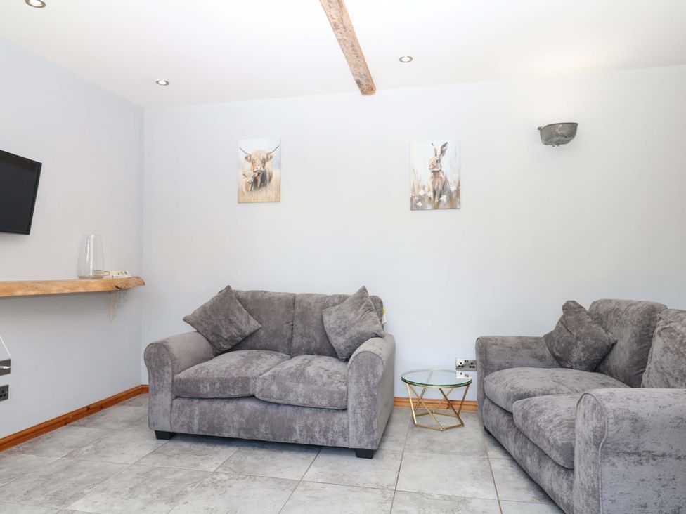 A living room with two sofas and a TV at The Milk Shed in Plymtree