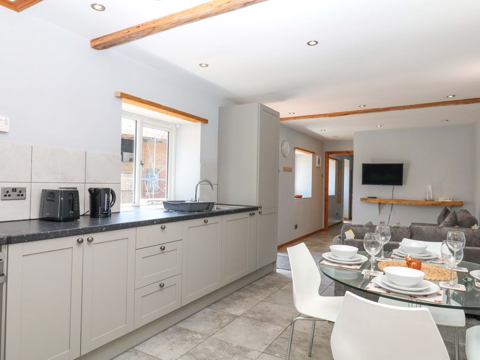 A kitchen with a dining table and chairs at The Milk Shed in Plymtree