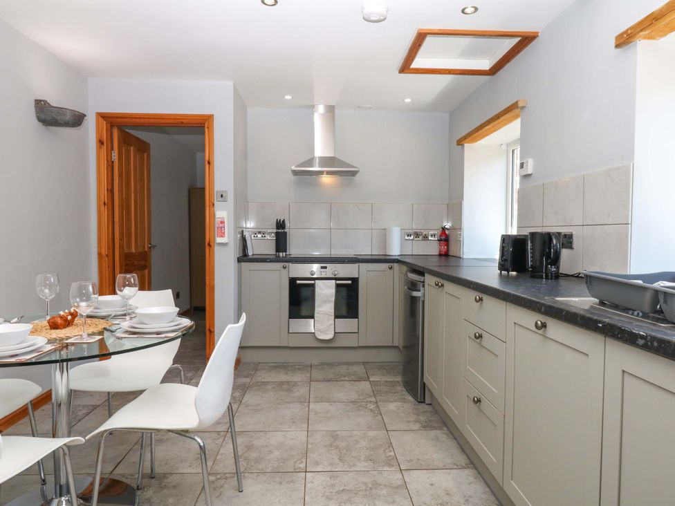 A kitchen with stove and dining table at The Milk Shed in Plymtree