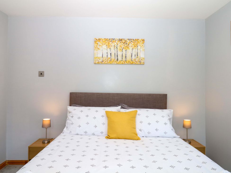 A bedroom with a bed and bedside tables at The Milk Shed in Plymtree