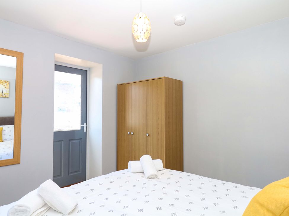 A bedroom with a bed and wardrobe at The Milk Shed in Plymtree