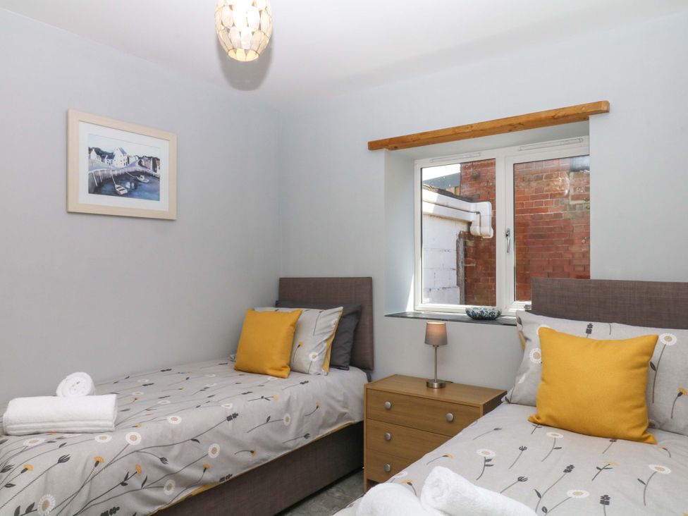 A bedroom with twin beds and a bedside table at The Milk Shed Plymtree